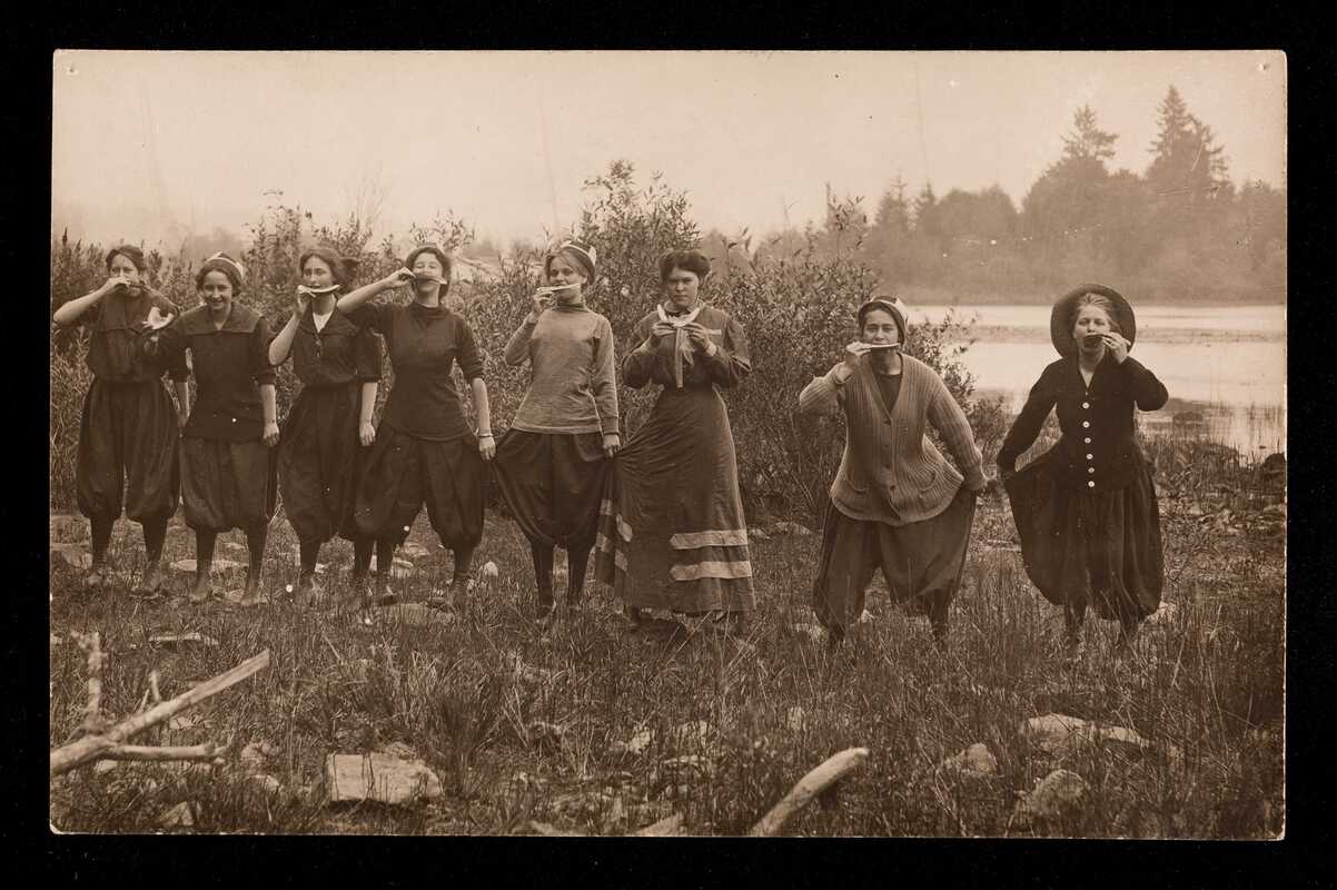 Line of eight women eating watermelon